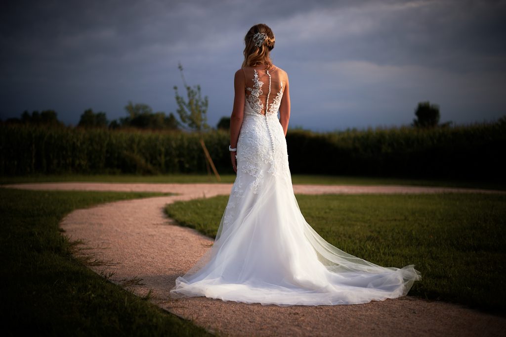 Mariée de dos en robe sur un chemin